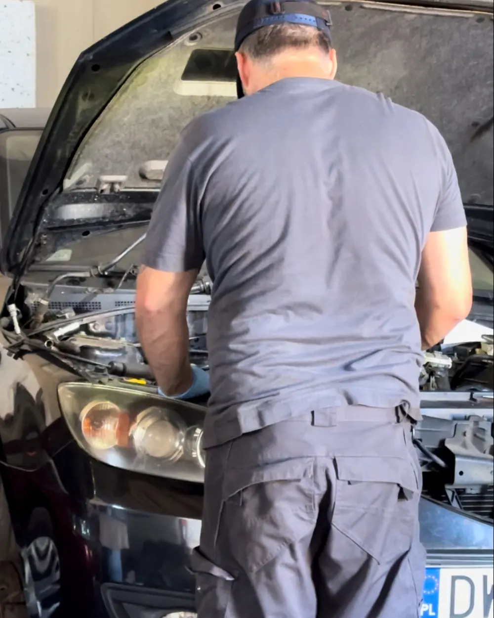 Mechanik pracuje przy aucie w hali warsztatu