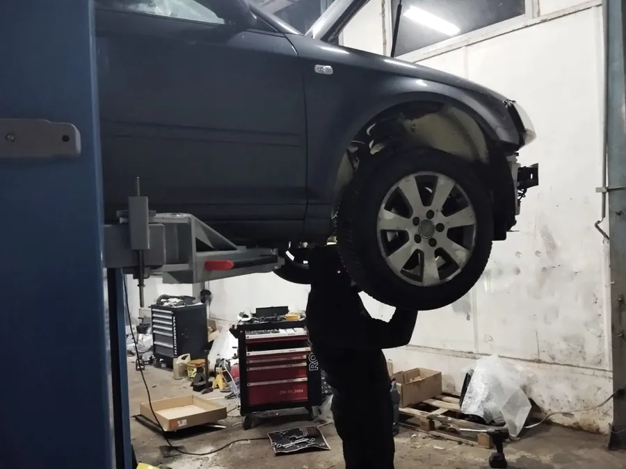 Mechanik zdejmuje koło z auta na podnośniku